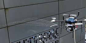 Drone, nettoyant la facade d'un bâtiment.